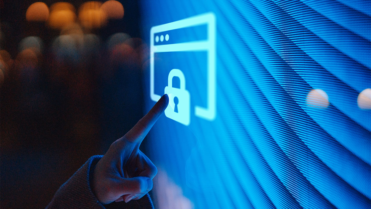 Nahaufnahme einer Hand, die einen beleuchteten digitalen Bildschirm mit einem Sperrzeichen berührt.